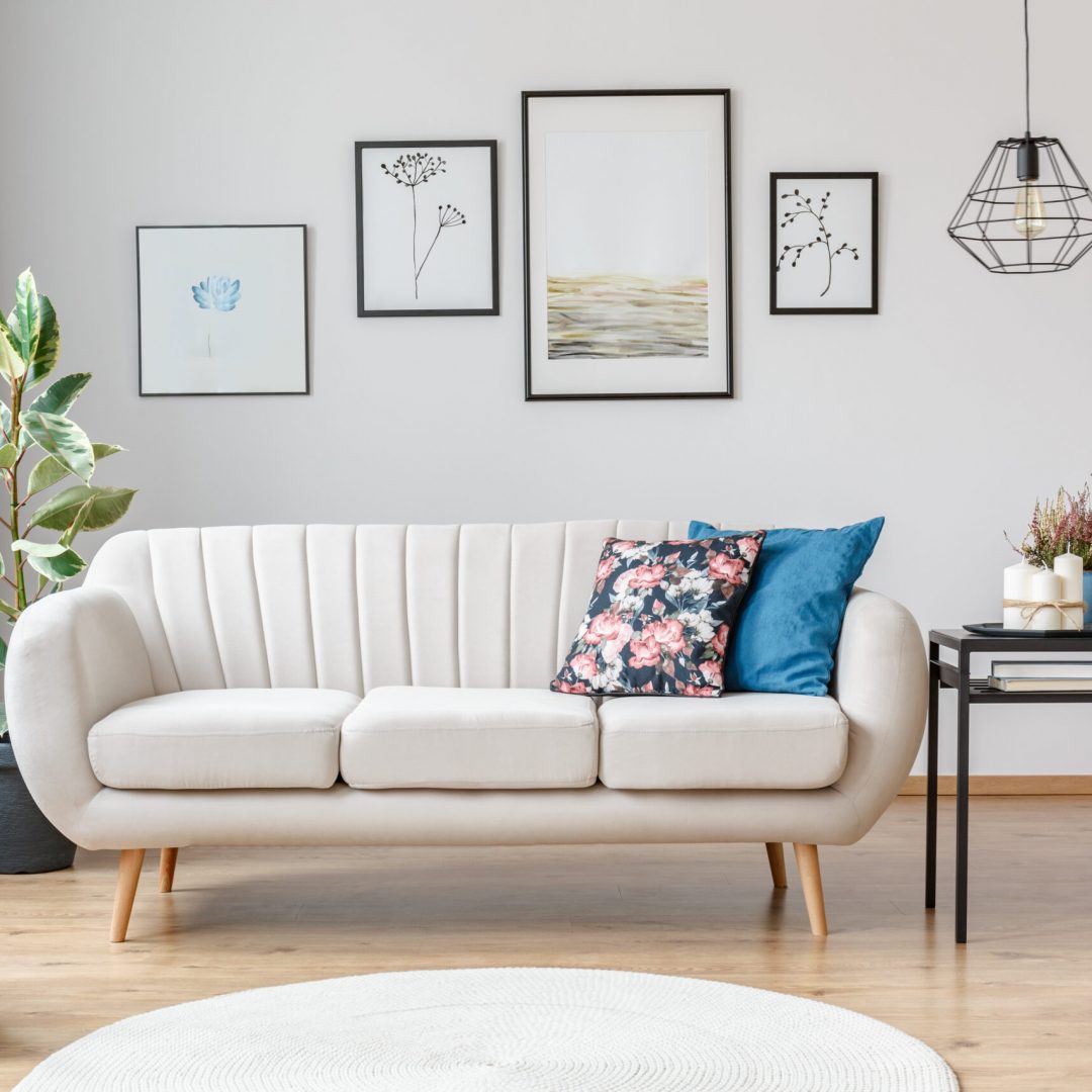 Floral,Pillow,On,Beige,Sofa,Next,To,Table,With,Candles